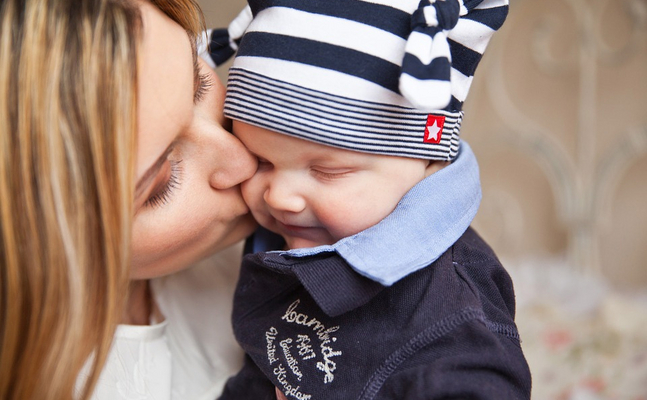 Mutter küsst Kind auf die Wange